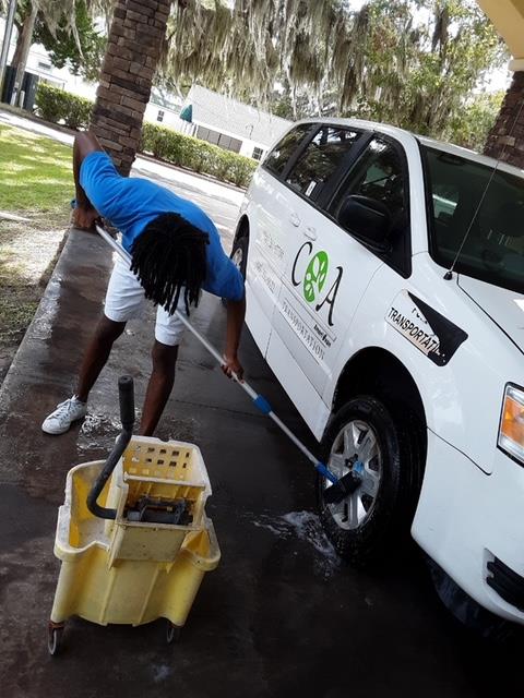 Student washing the Counsel on Aging Vehicle